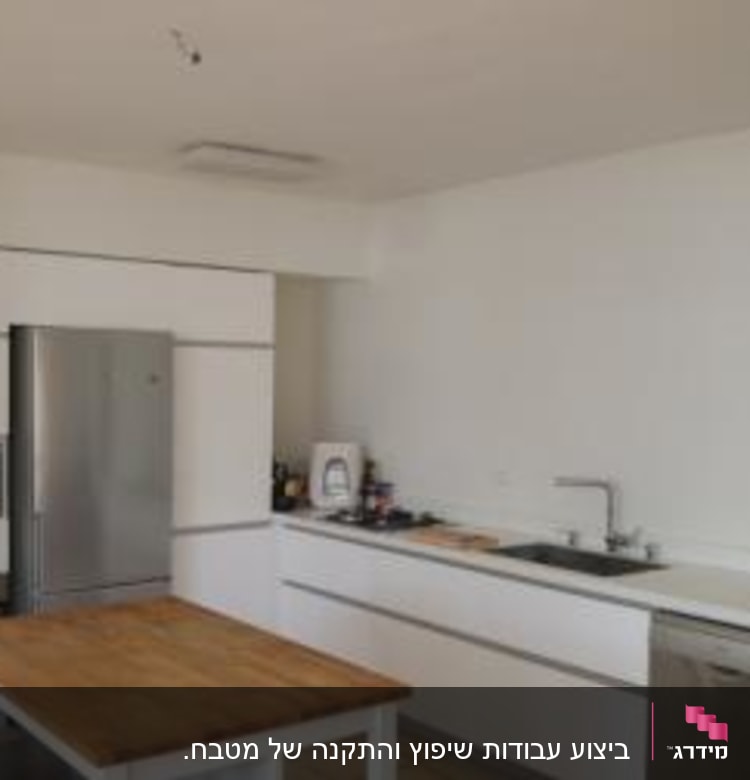 מטבח עם שולחן עץ, כיור ומדיח כלים